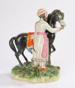 19th Century Staffordshire figural group, of a Turk standing with his stallion on a grassy base,