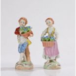 Pair of Dresden porcelain figures, of a young man and young lady holding blue flowers, the underside
