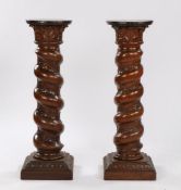 Pair of oak pedestals, the circular top above a thick barley twist columns carved with grape and