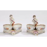 Pair of early 20th Century porcelain twin salts, surmounted by a standing putto above two foliate