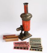 Lantern slide projector with red painted body, on a wooden plinth base, together with a collection