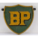 Cast metal BP sign, of shield form with raised yellow lettering on a green ground with raised yellow