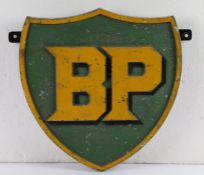 Cast metal BP sign, of shield form with raised yellow lettering on a green ground with raised yellow