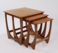 Nest of three G-Plan Astro teak occasional tables, the square tops raised on curved supports, the