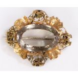 Victorian brooch, the yellow metal pierced and arch surrounding the central large facetted stone,