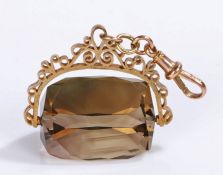 9 carat gold smoky quartz swivel seal, the facetted smoky quartz with a scrolling arm, 38mm diameter