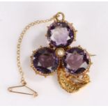 Victorian yellow metal and amethyst brooch, with three amethysts around a single pearl forming a
