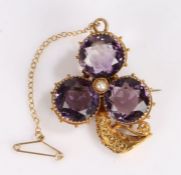 Victorian yellow metal and amethyst brooch, with three amethysts around a single pearl forming a