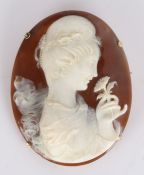 Early 20th Century cameo brooch/pendant, carved with a lady holding a flower just below her nose,