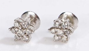 Indian white metal diamond set earrings, each stud set with seven round cut diamonds forming