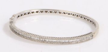 18 carat white gold diamond set bangle, with a row of baguette cut diamonds flanked to either side
