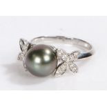 18 carat white gold pearl and diamond set ring, the central opal flanked by diamond set petals,