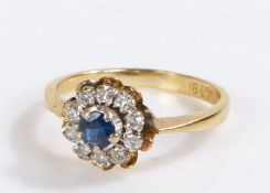 18 carat gold diamond and sapphire ring, the central sapphire with a cluster of diamonds