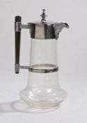 Silver plated clear glass claret jug, the hinged lid with beaded tapering finial, tapering ebony