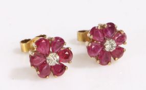 Pair of 9 carat gold ruby and diamond ear studs, with a central illusion set diamond with a ruby