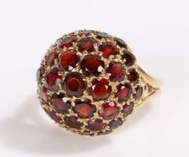 9 carat gold garnet set ring, the dome head set with a series of round cut garnets, 7.4 grams,