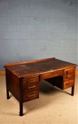 Mid 20th Century oak desk, with three frieze drawers and two drawers to each pedestal, 135cm wide
