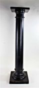 20th century ebonised wooden torchere stand, having square platform above round column and square
