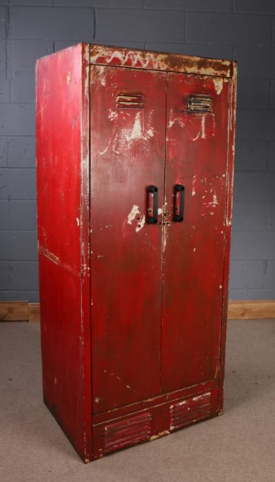 20th Century industrial steel cabinet, painted in red, the pair of vented hinged doors enclosing