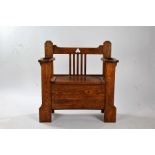 Arts and Crafts oak hall seat, having stick stand divisions either side of a storage seat, with