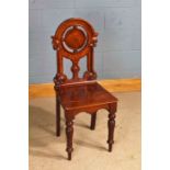 19th century mahogany hall chair, having arched pierced back in the gothic taste, raised on baluster