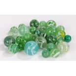 Collection of 19th century and later green glass marbles, most with opaque bands, the largest