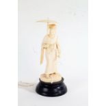 Two Japanese ivory Okimonos, early 20th Century, as a lady holding an umbrella and the other with