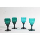 Matched set of four 19th Century English green glass wine glasses, with a tapering bowl above a stem