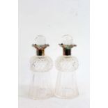 Pair of decorative cut glass decanters, the silver plated collars above bulbous necks and flared