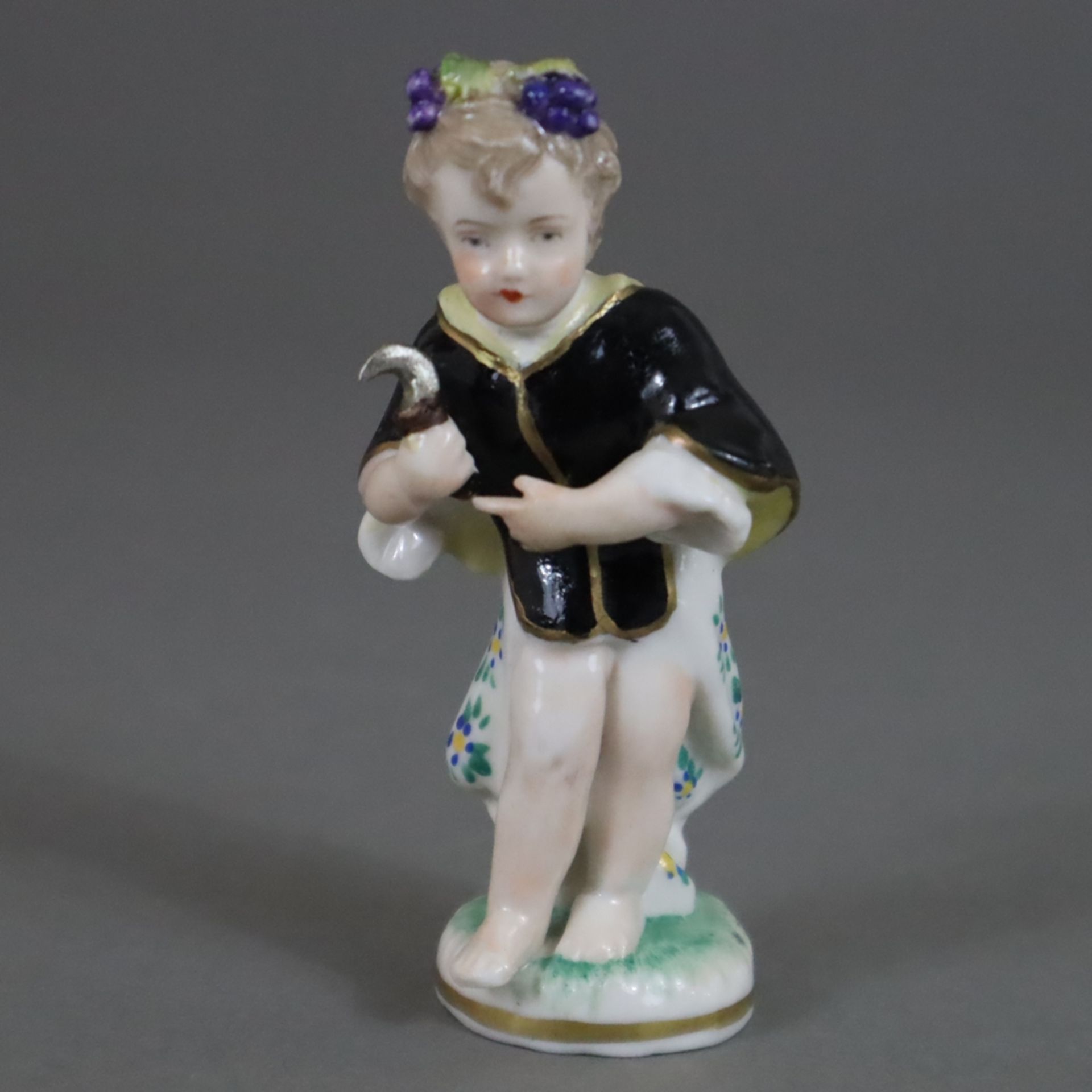 Allegorie auf den Herbst - Porzellan, farbig -und goldstaffiert, kleine Figurine mit Weinreben im H