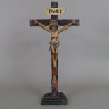 Standkruzifix - Holz, geschnitzt, polychrom gefasst, Korpus Christi im Dreinageltypus, am Fuße des