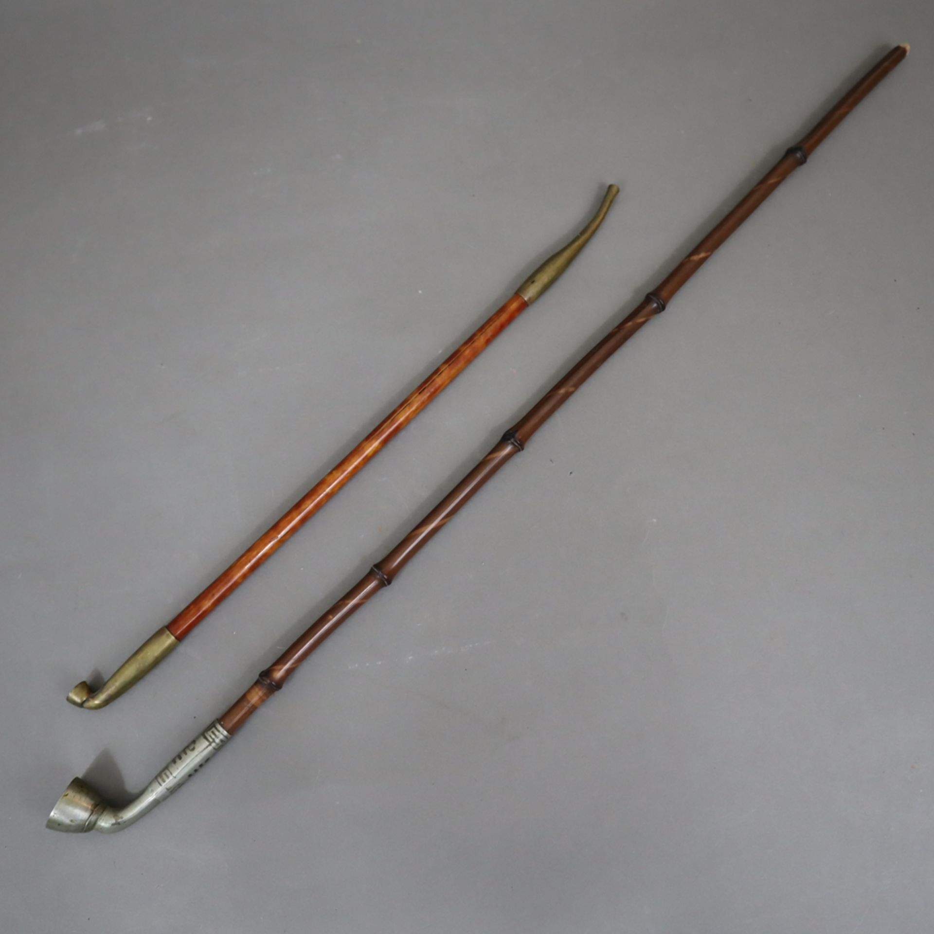 Zwei Opiumpfeifen - China, Messing- bzw. Weißmetallkopf, L. jeweils ca.33/53 cm, Gebrauchsspuren, 1