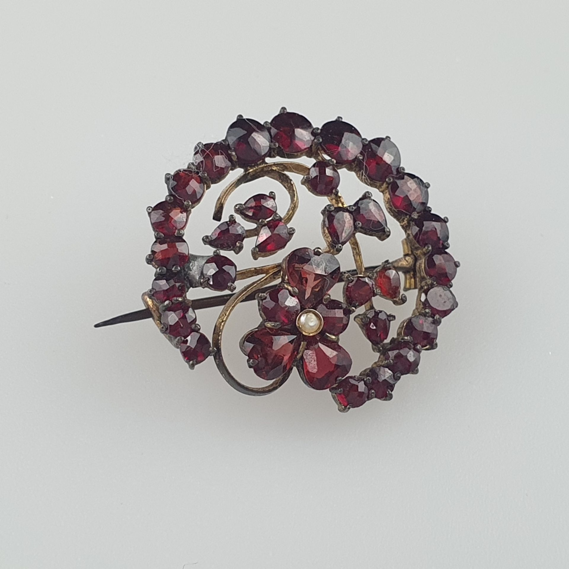 Granatbrosche - Tombak, von Kranz umgebene Blütenform, besetzt mit facettierten Granaten und einer
