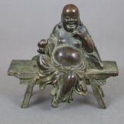 Glücksbuddha - Kupferfigur, bronziert, der dickbäuchige Budai in lockerer Sitzhaltung auf einer Ban