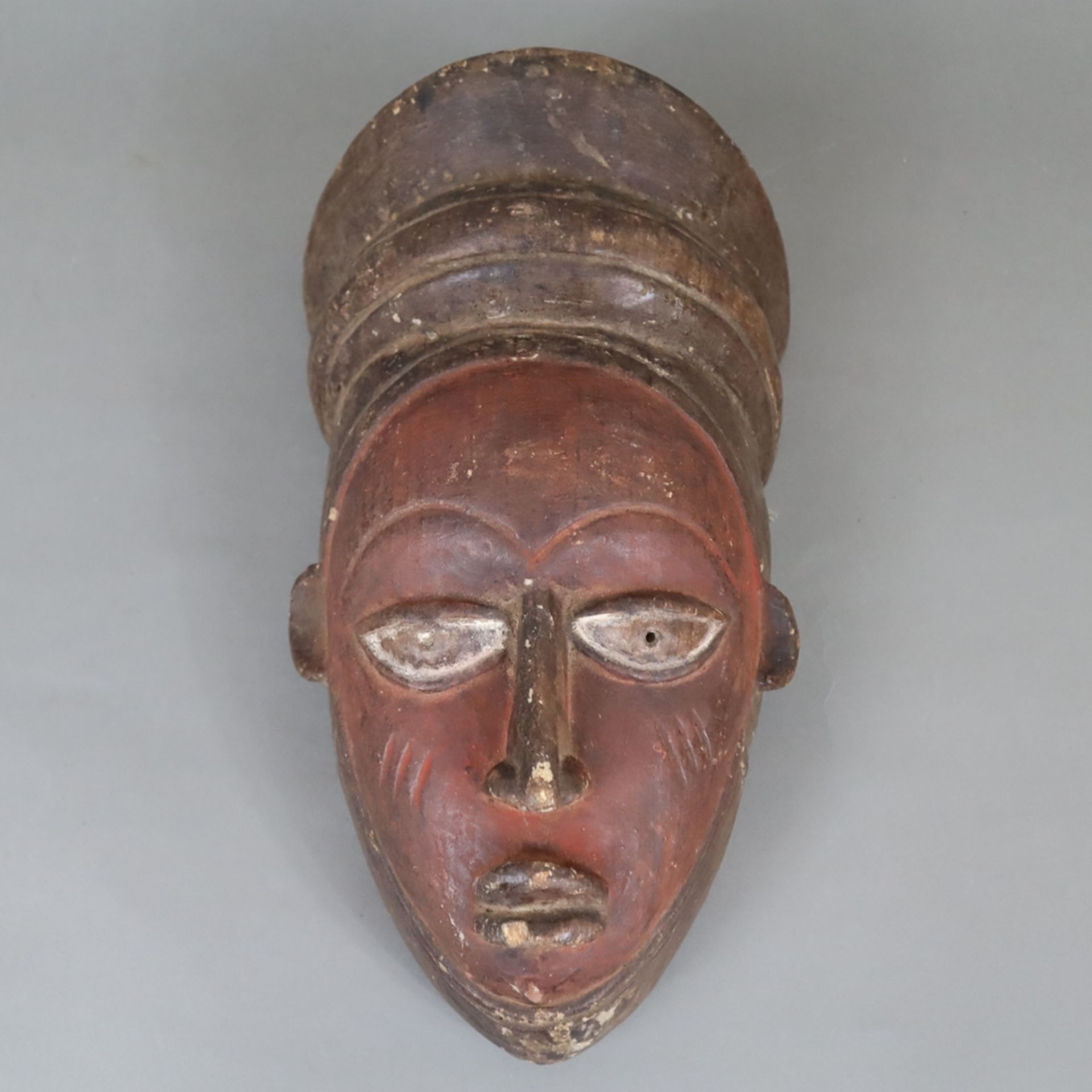 Afrikanische Holzmaske - Holz dunkel gefärbt, schwarz und rot eingefärbt, Ränder mit runden Durchbo