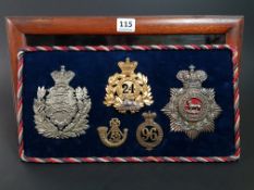 MAHOGANY DISPLAY CASE CONTAINING VICTORIAN HELMET PLATES AND GLENGARRY BADGES DUKE OF LANCASTER'S