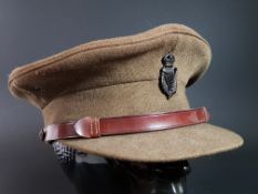 ANTIQUE BRITISH ARMY OFFICERS PEAKED CAP AND ROYAL IRISH CONSTABULARY CAP BADGE