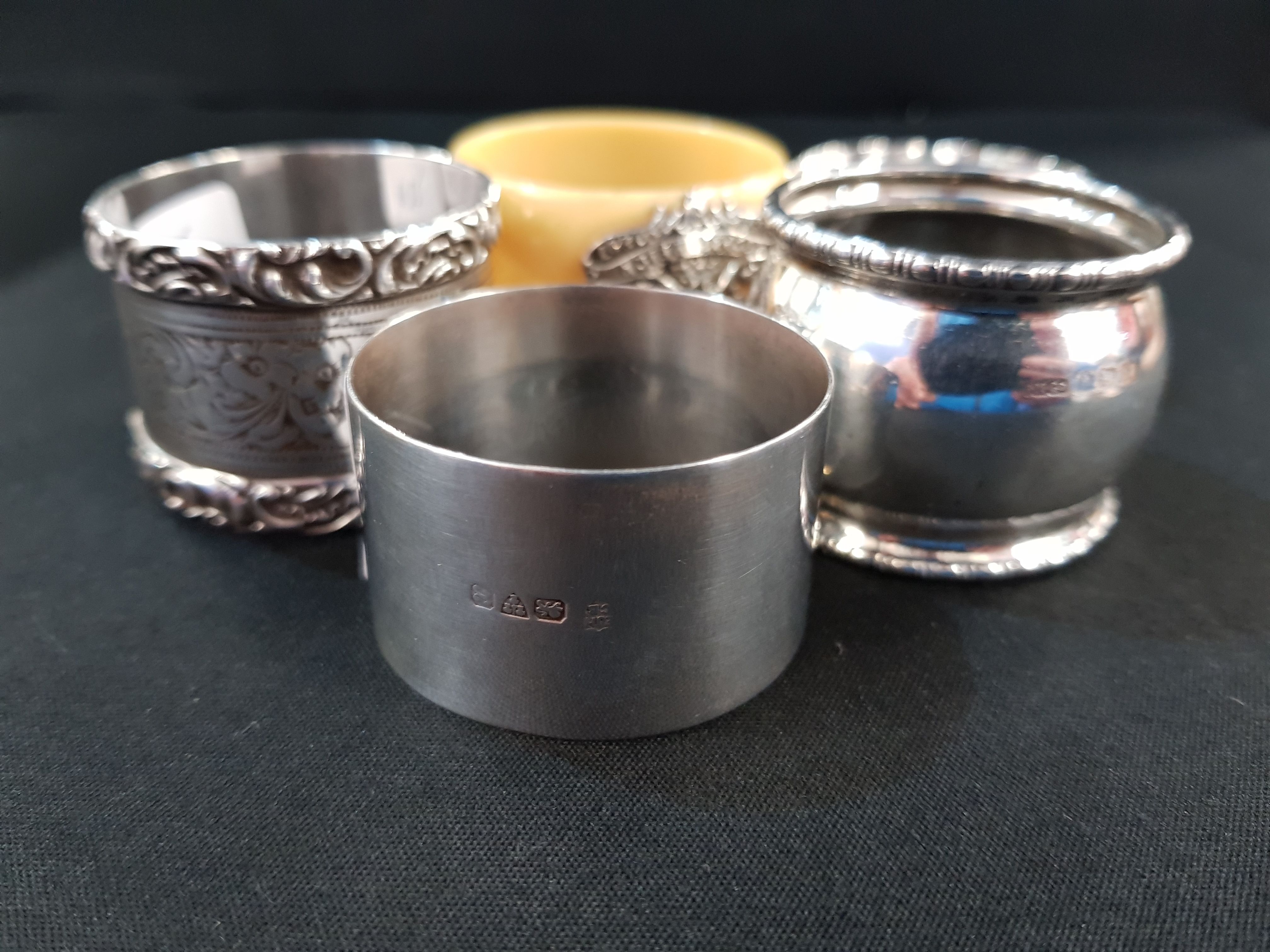 4 SILVER NAPKIN RINGS AND 1 OTHER WITH SILVER CREST