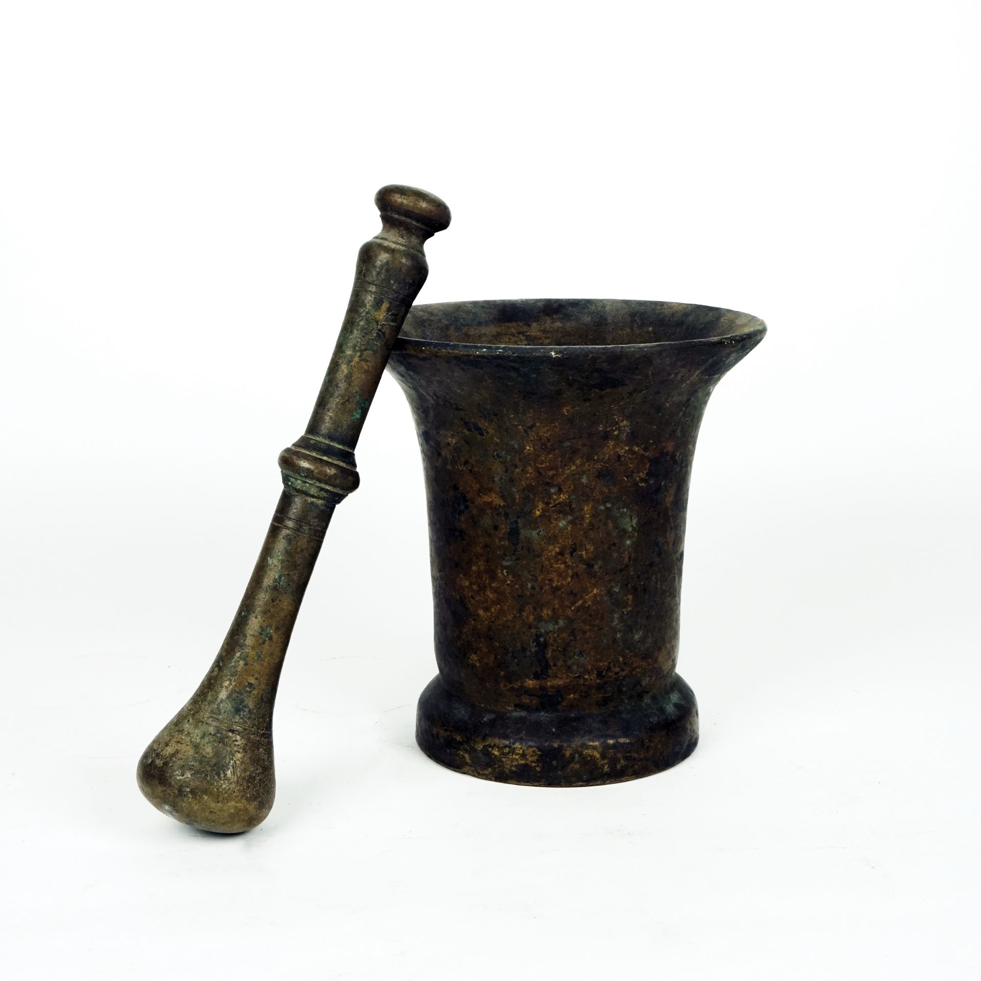 An antique patinated bronze mortar with pestle 20by19cm., the pestle 27cm. long