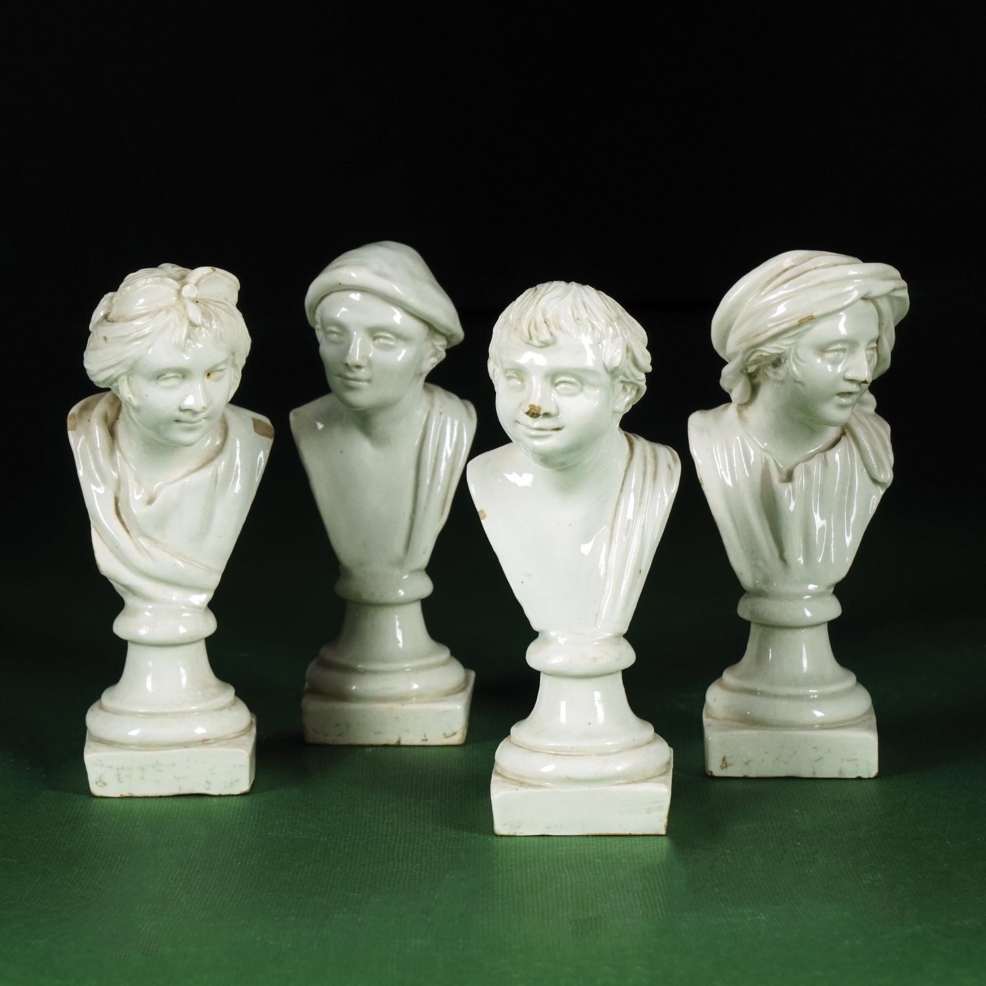 4 Neapolitan white terraglia small busts, 19th century 11cm. high each (one bust with the nose