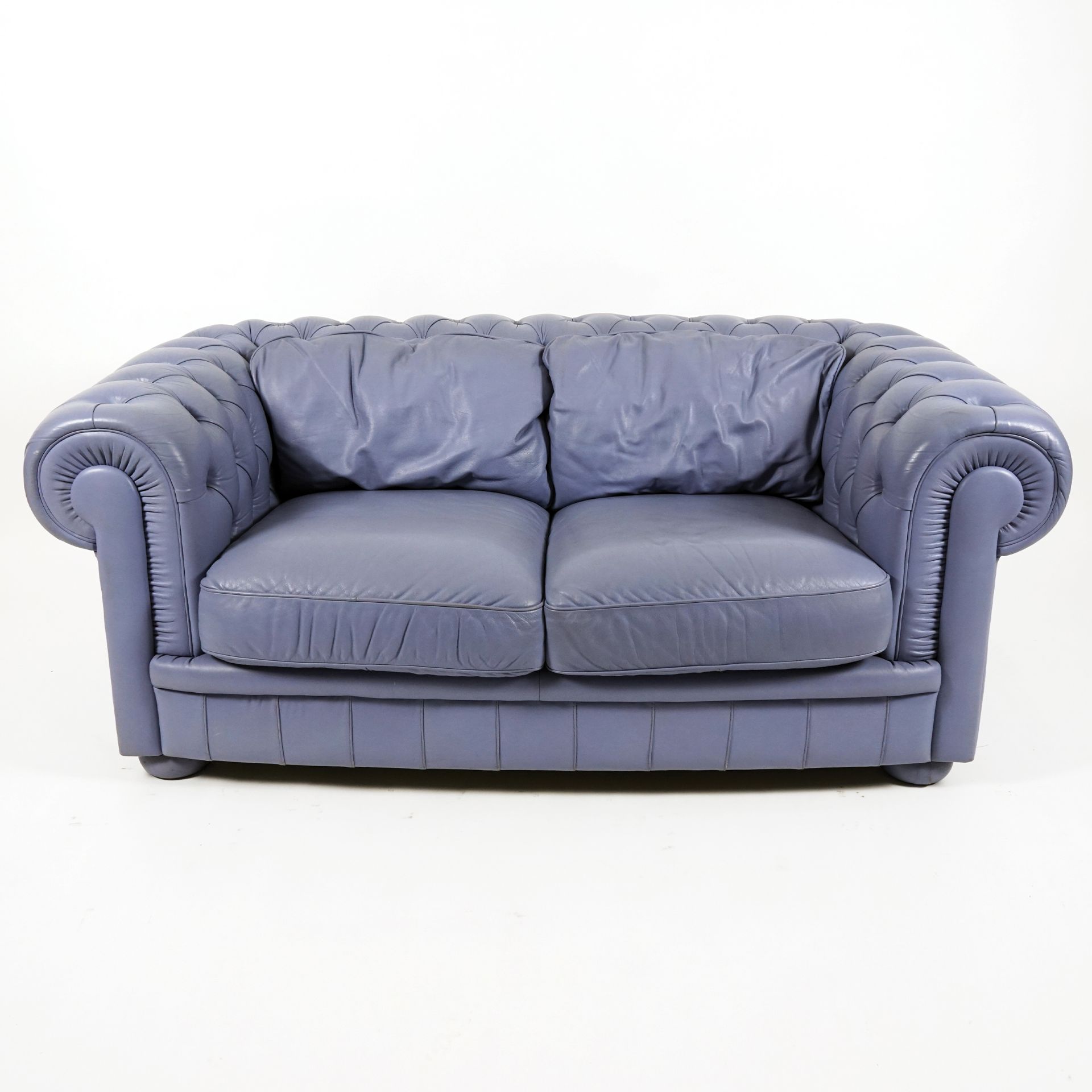 An elegant periwinkle leather covered sofa with with goose down padded pillows 70x175x93cm.