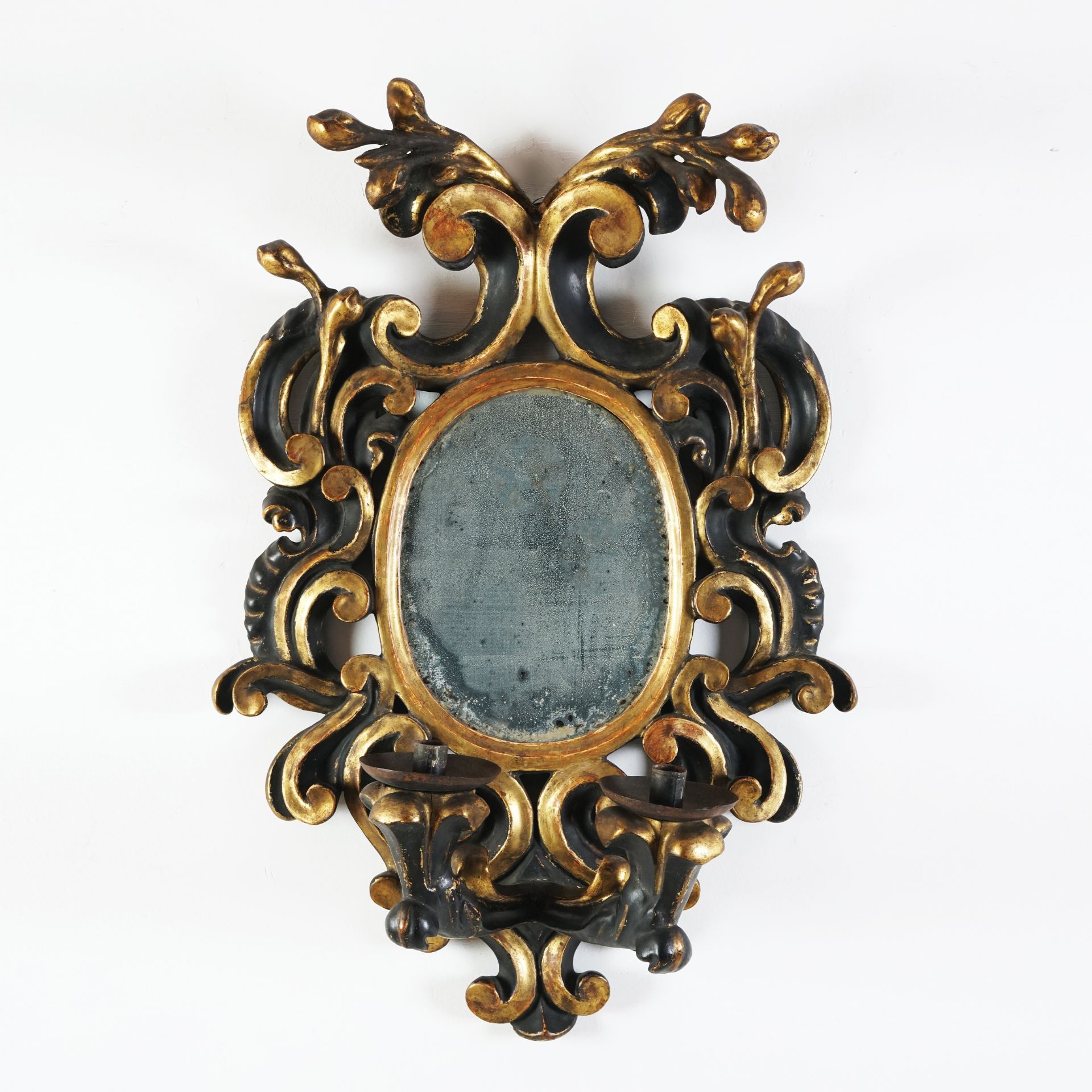 A Roman black lacquered and gilt wood two-branch wall mirror, 17th century 27by20,5cm. sight size;