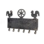 A black-painted iron mural utensil rack