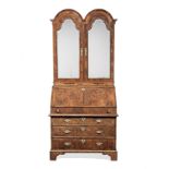 A George II figured-walnut and featherbanded double-domed bureau cabinet, circa 1730