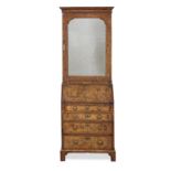 A George II walnut and featherbanded bureau cabinet of narrow proportions