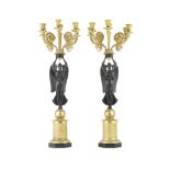 A pair of 19th century French gilt and patinated bronze figural six light candelabra in the Empir...