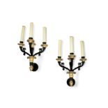 A pair of French black patinated and gilt bronze three light wall appliques in the Restauration s...