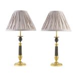 A pair of French Restauration patinated and gilt bronze candlesticks adapted as lamp bases (4)