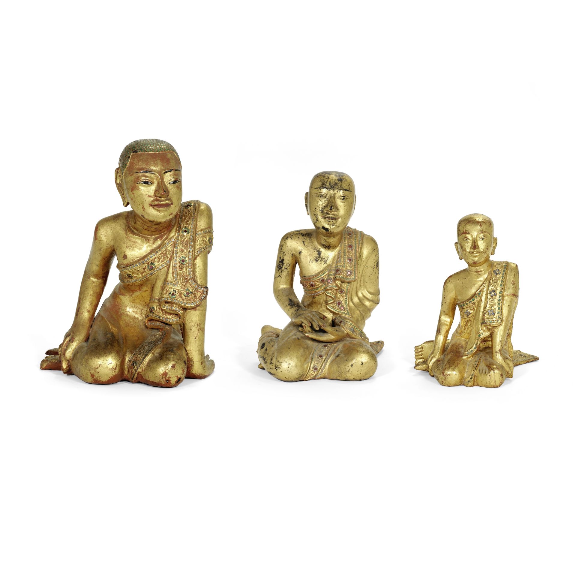 Three Burmese carved and giltwood figures of kneeling monks of varying sizes probably 19th centur...