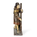 A 16th century carved and polychrome wood figural fragment depicting a man holding a staff or cro...